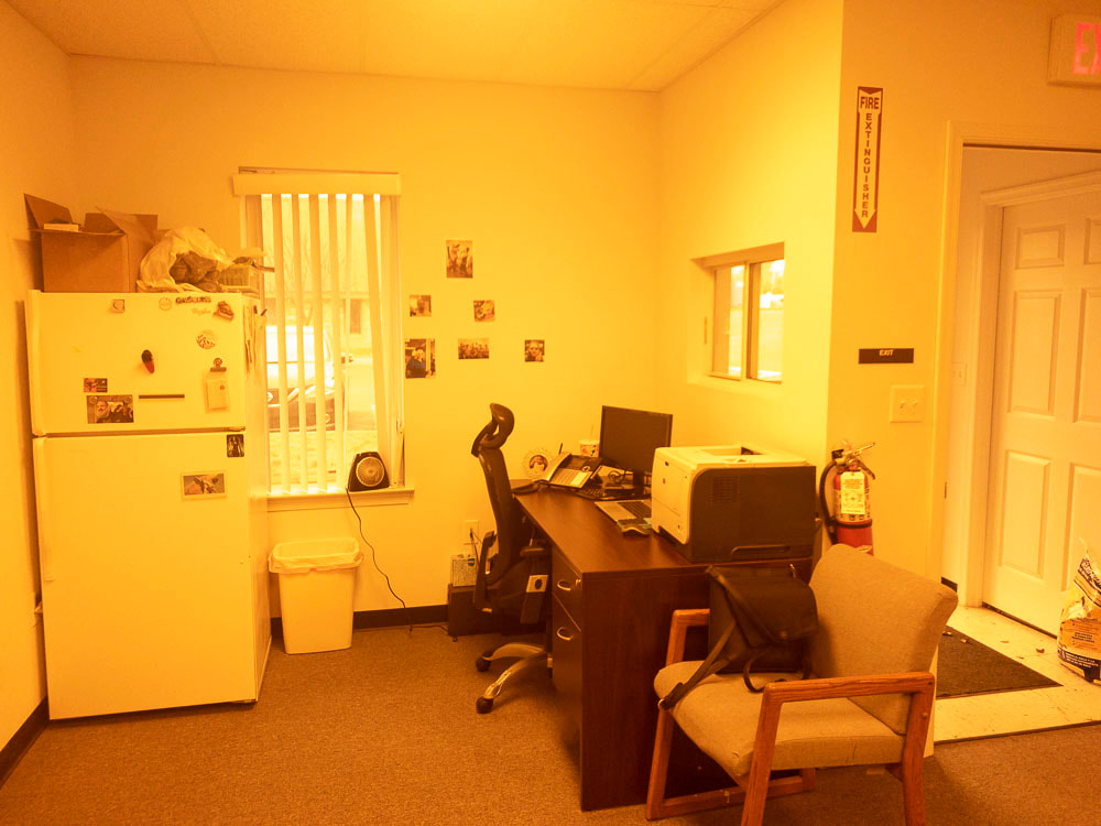 A view of an office room with the 511 tint, casting a deep red hue throughout the space, intensifying warm tones and creating a strong color cast over the furniture and room details.