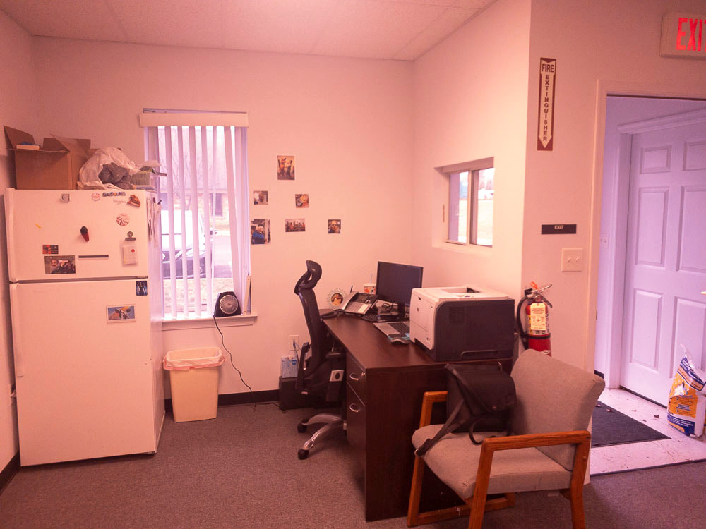 A view of an office room under a medium plum tint, applied by the COI filter, adding a purplish cast that subtly alters the room’s hues and introduces a soft, muted quality to the details.