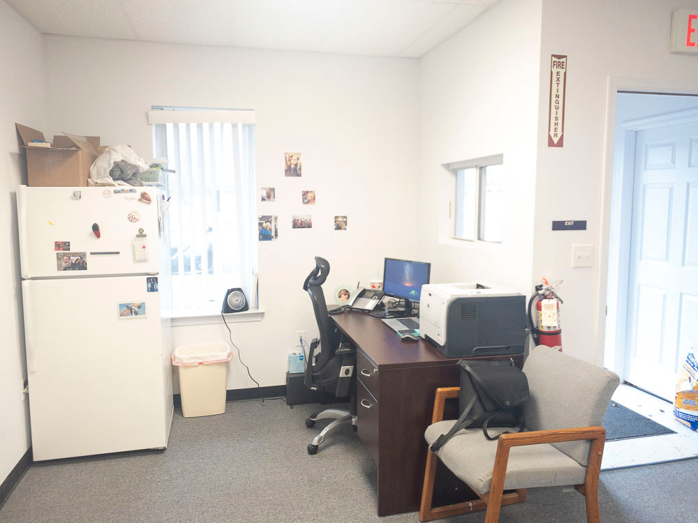 A view of an office room under a medium blue tint, applied by the E-30 filter, providing a moderate blue shade that cools the room's appearance without overly obscuring details.