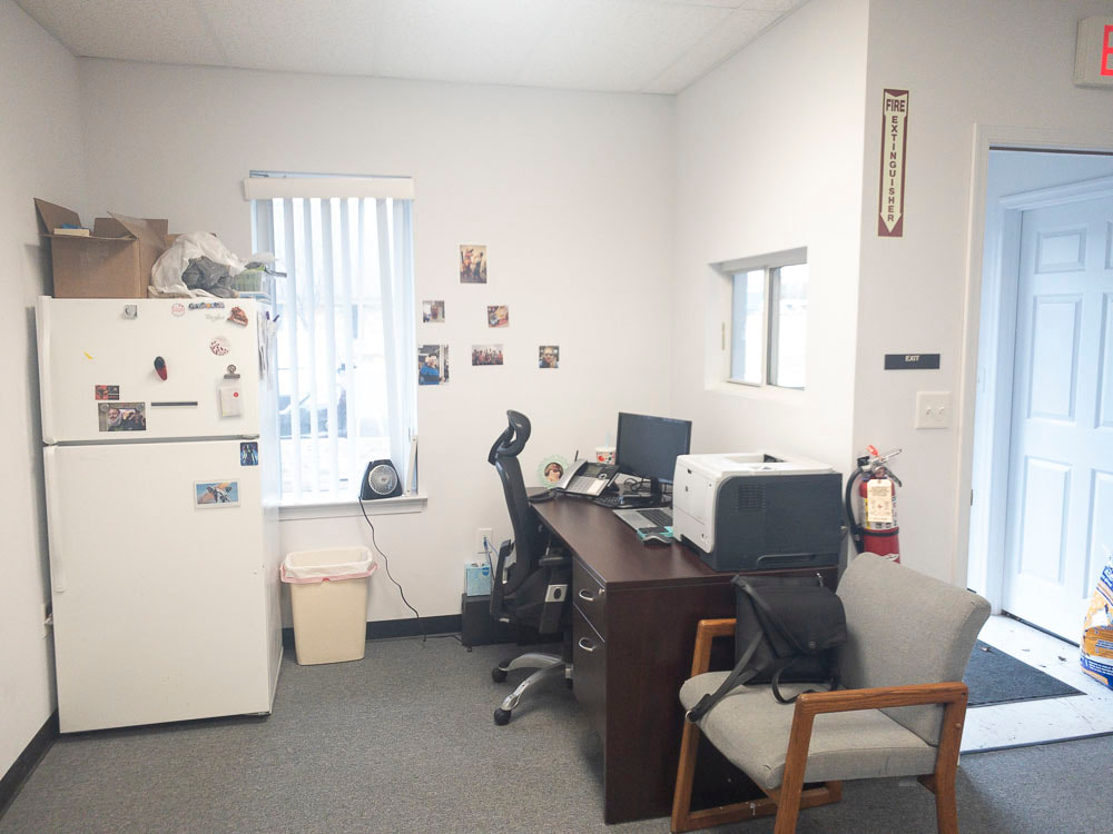 A view of an office room under a dark blue tint, applied by the E-50 filter, casting a strong blue tone over the entire room and significantly darkening the visibility of furniture and details.