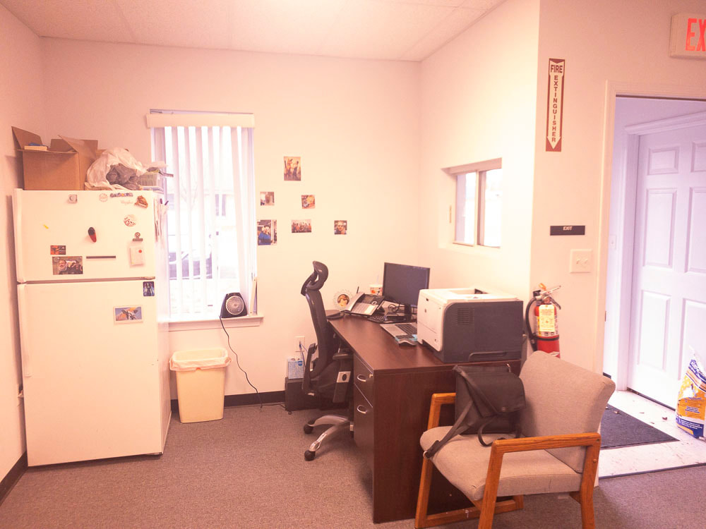 A view of an office room under a medium rose tint, applied by the FL-41 filter, creating a soft pinkish hue that subtly warms the overall ambiance and slightly softens the room’s details.