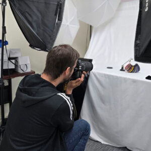marketing_chadwick_optical Andrew, Marketing Associate, photographing product samples in a studio setup.