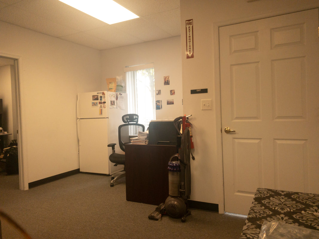 The office room as seen through a warm, brightening filter applied by Noir 12, casting a slight amber glow across the room and enhancing warmth without obscuring details.
