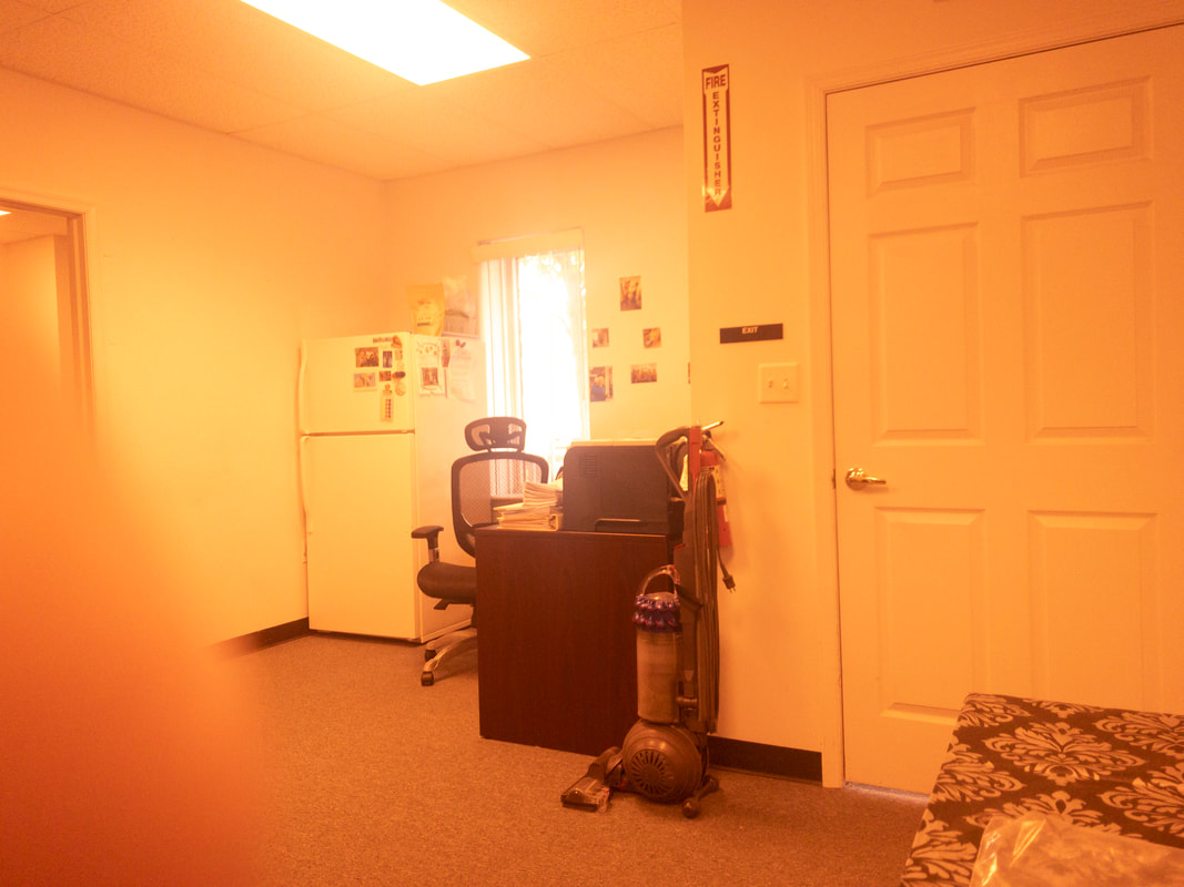 A view of an office room under a very dark tint, applied by the Noir 47 filter, resulting in a dimmed view that heavily reduces visibility and details in the room.