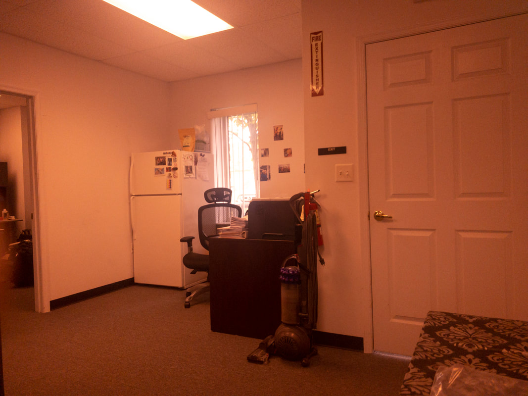 An office room seen through the Noir 81 tint, producing a reddish-brown filter effect over the scene, slightly muting colors and adding a warm overlay to the objects and furniture.