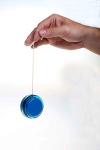 yoyo Close-up of a hand holding a blue yo-yo by its string.